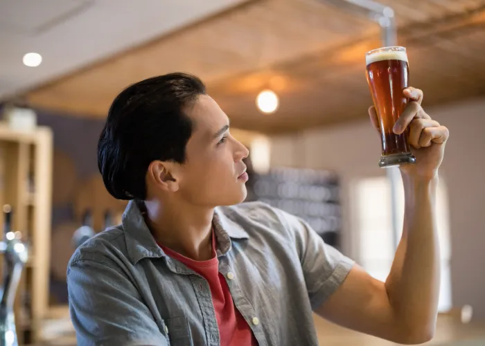 man looking at a glass of beer